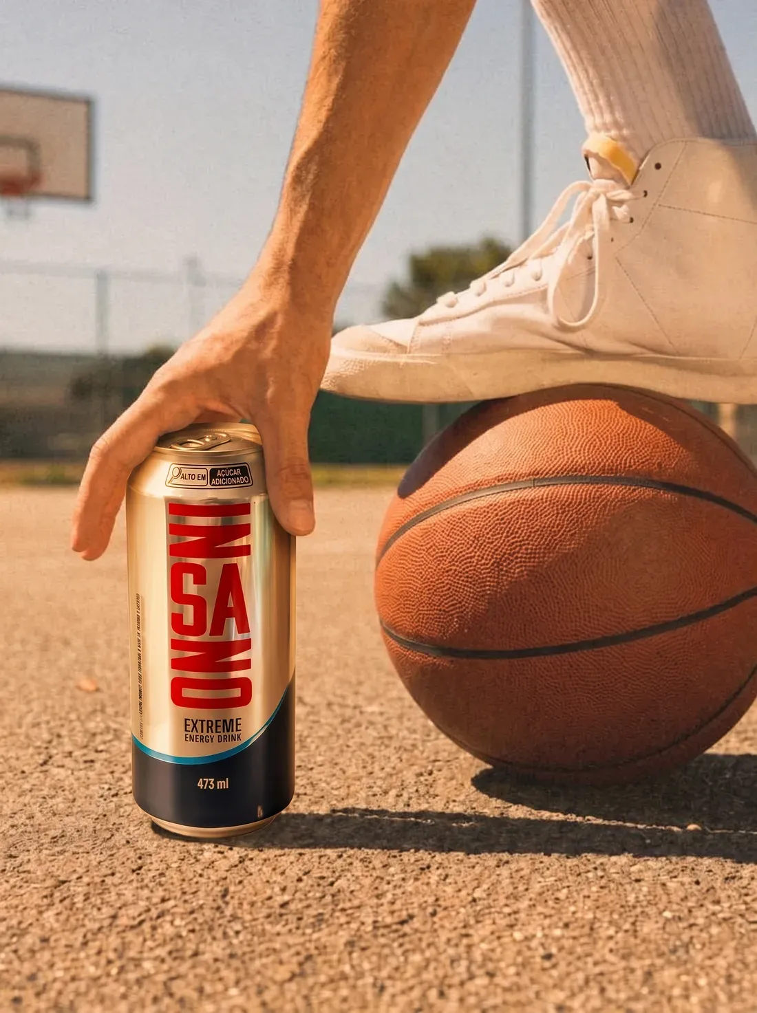 Lata Insano de 473 mL ao lado de uma bola de basquete na quadra