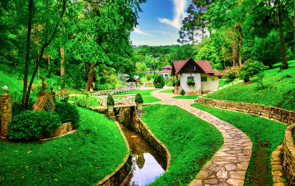 Jardins arborizados e curso d’água entre os caminhos da Estância Ouro Fino